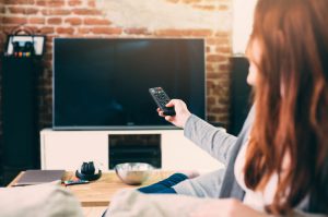 Woman switching the channels on the TV.